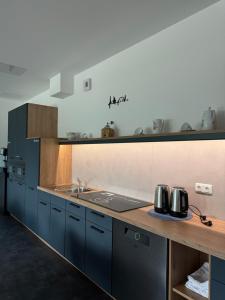 a kitchen with blue cabinets and a counter top at City Inn Schwedt in Schwedt
