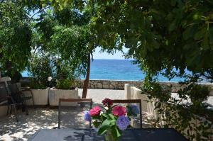 a view of the ocean from a table with flowers at Angelina in Jakišnica