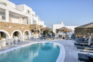 a swimming pool with chaise lounge chairs and a hotel at Nodo Boutique Hotel in Mikonos