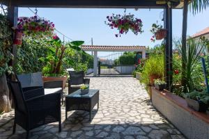 a patio with chairs and a table and flowers at House garden in Sperlonga