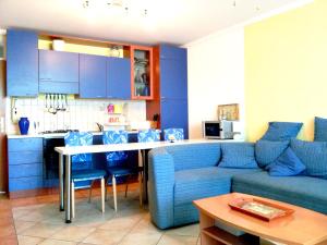 a living room with a blue couch and a kitchen at Beach Apartment Sveti Filip i Jakov - Turanj in Sveti Filip i Jakov