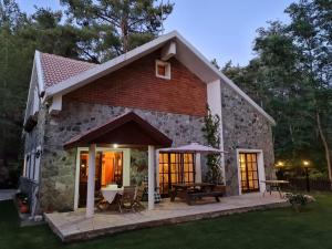 a small stone house with a table and chairs at VILLa ENRIETTe - Panoramic Mountain Retreat in Pano Platres, Cyprus in Kato Platres