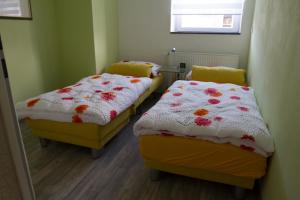 two beds in a small room with flowers on them at Ferienhaus Borneich in Schwalbach