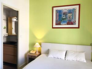 a bedroom with a bed and a picture on the wall at Hotel Aux Sacres Reims, Centre Historique in Reims