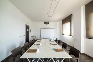a large conference room with a long table and chairs at Phi Hotel Milano in Baranzate