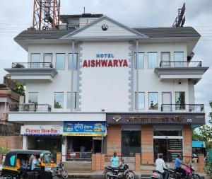 潘达尔普尔Hotel Aishwarya的一座有骑摩托车的人在前面的建筑