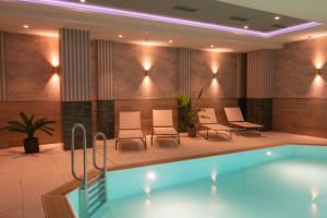 a pool in a hotel room with chairs and tables at Van der Valk Hotel Hildesheim in Hildesheim