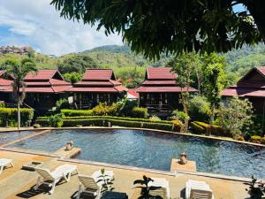 una piscina en un complejo con sillas y edificios en Kantiang Seahorse Resort & Spa, en Ko Por