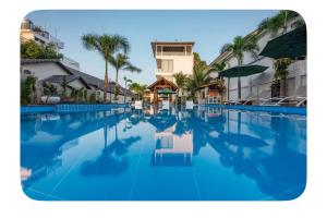 a large swimming pool with blue water and palm trees at Villa caribe phu quoc in Phú Quốc +17 photos