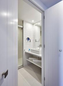 a white bathroom with a sink and a mirror at Delamar 4*Sup-Adults only (18+) in Lloret de Mar