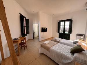 Un dormitorio con dos camas y una mesa y un televisor. en La Arequera, en San Antonio de Areco 10 fotos más