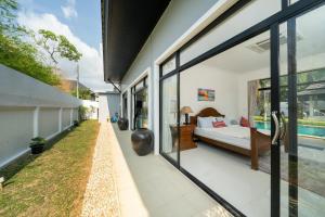 1 dormitorio con vistas a la piscina a través de puertas de cristal en Bua Sawan - 4 Bedrooms Pool Villa, en Ban Pak Lak 54 fotos más