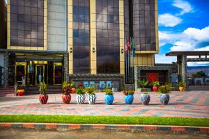 Un edificio con un montón de jarrones con plantas en ellos. en GR Comfort Hotel, en Mbeya
