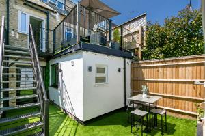a small backyard with a table and a balcony at Stunning 4 Bedroom Townhouse in Cirencester in Cirencester