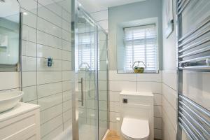 a bathroom with a toilet and a glass shower at Stunning 4 Bedroom Townhouse in Cirencester in Cirencester +14 photos