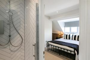 a bedroom with a bed and a shower at Stunning 4 Bedroom Townhouse in Cirencester in Cirencester