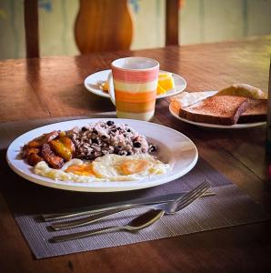 a plate of breakfast food on a wooden table at Ventanas en Corcovado in Dos Brazos
