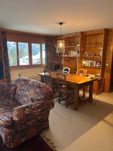 a living room with a couch and a wooden table at Mountain View perfect retreat in Crans in Lens