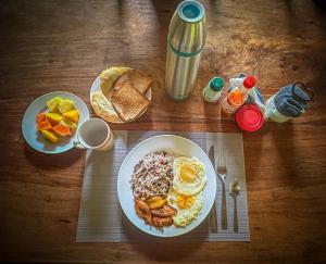 a wooden table with a plate of breakfast food at Ventanas en Corcovado in Dos Brazos