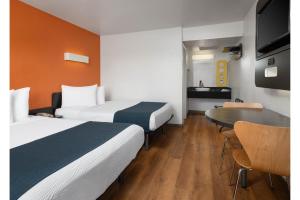 a hotel room with two beds and a table at Motel 6-Green Bay, WI - Lambeau in Green Bay +19 photos