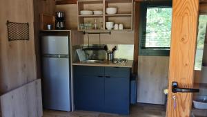 a small kitchen with a sink and a refrigerator at Camping Onlycamp du lac de Roybon in Roybon