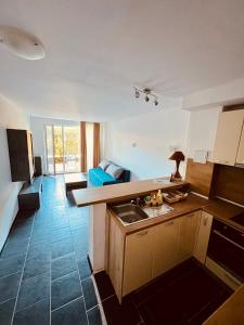 a kitchen with a sink and a living room at Limani Guest house in Sozopol