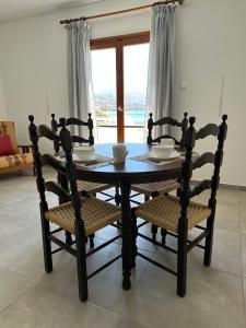 a dining room table and chairs with a window at EL.DO.SO in Gavrio