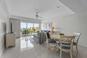 a living room with a table and chairs and a couch at Beachfront - Supreme View 2BR condo - A344 in Palm-Eagle Beach