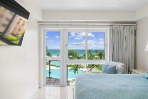 a bedroom with a bed and a view of the ocean at Beachfront - Supreme View 2BR condo - A344 in Palm-Eagle Beach +50 photos