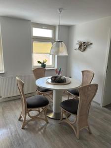 a dining room with a white table and chairs at Kerstins Lieblingsdomizil in Oelsnitz