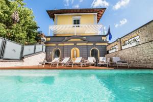 a house with a swimming pool with chairs and a building at LHP River Club in Florence