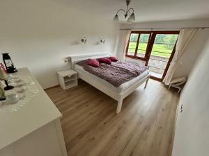 a bedroom with a bed with pink pillows on it at Nicole in Hartau