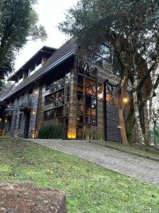 a home with a large building with windows at Celeiro Lake Village in São Francisco de Paula