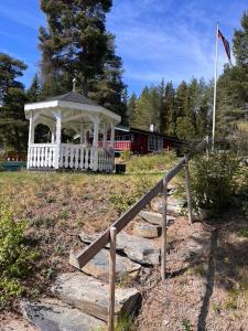 a white gazebo with a fence and a train at Glampingtelt i fjordkanten, Rønlund Hyttepark in Ron +1 photo