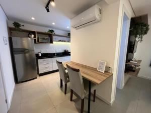 eine Küche mit Tisch und Stühlen und einem Kühlschrank in der Unterkunft Loft com vista para Vila Germânica 309 in Blumenau