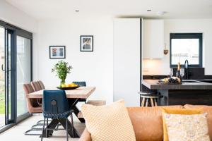 a living room with a couch and a table at The Cotswold Light House ML63 Lower Mill Estate in Somerford Keynes +13 photos