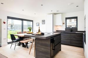 a kitchen and dining room with a table and chairs at The Cotswold Light House ML63 Lower Mill Estate in Somerford Keynes