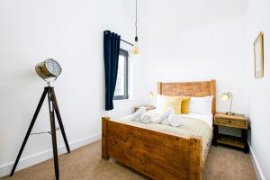 a bedroom with a bed with a camera on a tripod at The Cotswold Light House ML63 Lower Mill Estate in Somerford Keynes