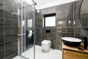 a bathroom with a shower and a toilet and a sink at The Cotswold Light House ML63 Lower Mill Estate in Somerford Keynes