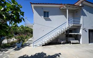 a white house with stairs and a chair at Anchor Villa in Troulos