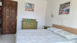a bedroom with a bed and a dresser and a door at Sunny Coastal 1 Bed Apartment - Vera Coast: 2mins to Beach in Los Amarguillos +30 photos