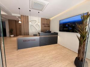 una oficina con recepción y TV en la pared en Noam Luxury Hotel, en Sarandë