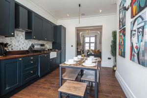 a kitchen with green cabinets and a table with dishes on it at Spacious High End 3-Bedroom Apartment Sleeps 6 in Midland
