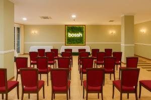a room with red chairs and a table with a sign that readsbush at Hotel Bossh Alicia in Albacete