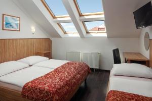 a hotel room with two beds and a flat screen tv at Hotel Superior Prague in Prague