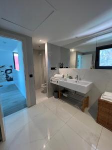 Un baño con lavabo y un espejo grande. en VILLA Cooper l HEATED Pool l PVT Garden I GOLF I SEA VIEWS, en San Bartolomé