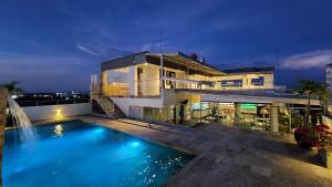 a house with a swimming pool in front of a building at BCA HOTEL in Barrancabermeja