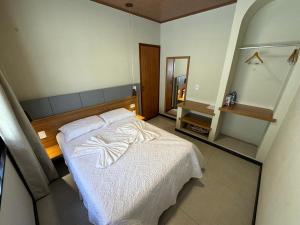 a bedroom with a white bed and a mirror at Vila dos Poetas - 02 quartos - GD in Barreirinhas