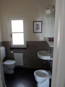 baño con aseo y lavabo y ventana en La Rimessa, en Bonassola