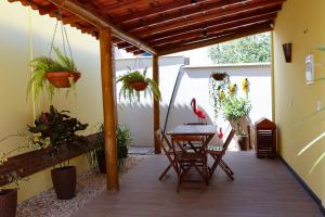 a patio with a table and chairs and potted plants at Vila dos Poetas - 02 quartos - GD in Barreirinhas